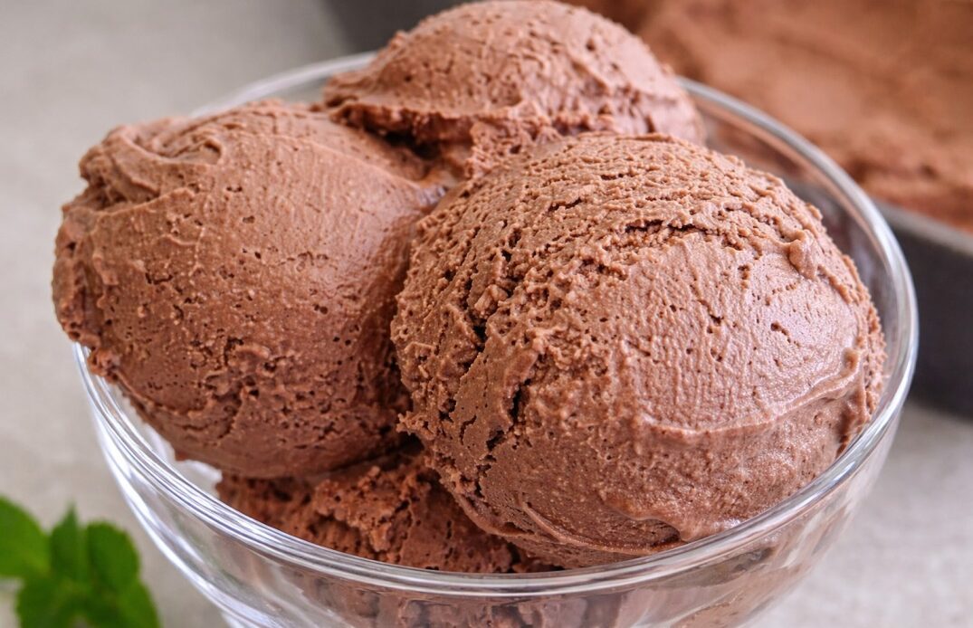 homemade chocolate ice cream scoops in glass bowl with rich texture