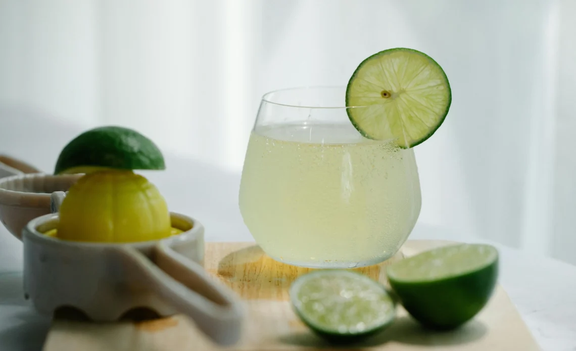 Refreshing homemade ginger beer served with fresh lime slices in a glass