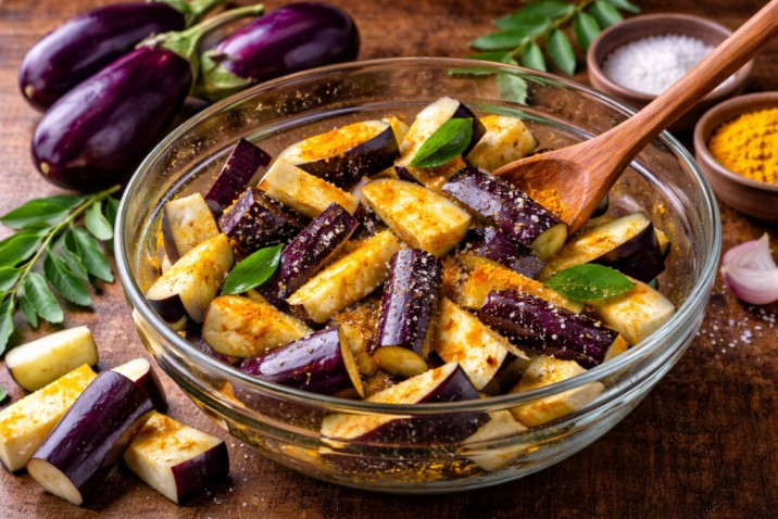 chopped eggplant pieces mixed with spices and curry leaves for Sri Lankan wambatu pahi preparation