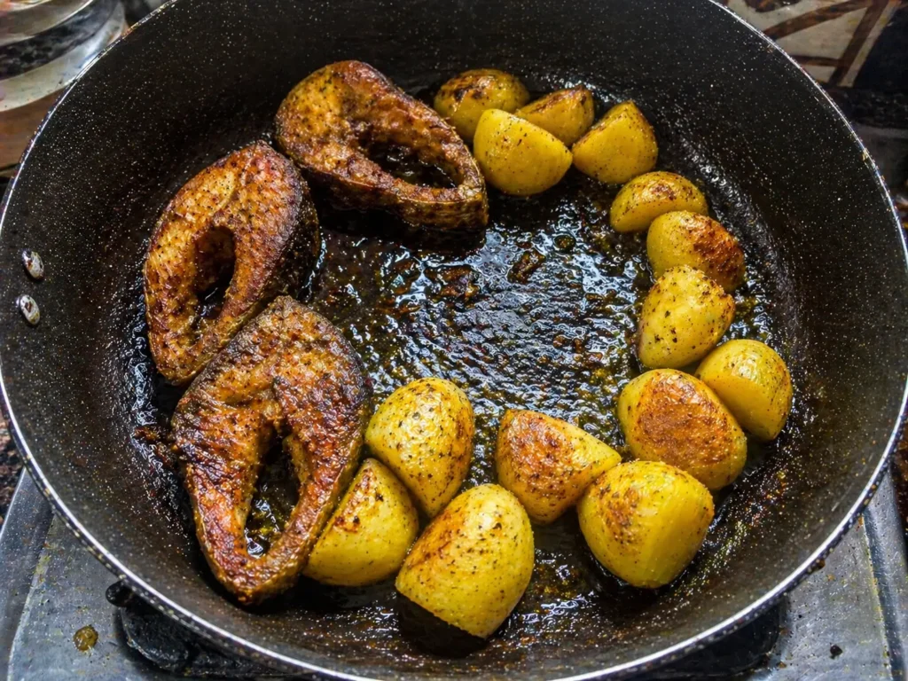 fish and potatoes frying in pan with oil for one pot fish potato rice recipe