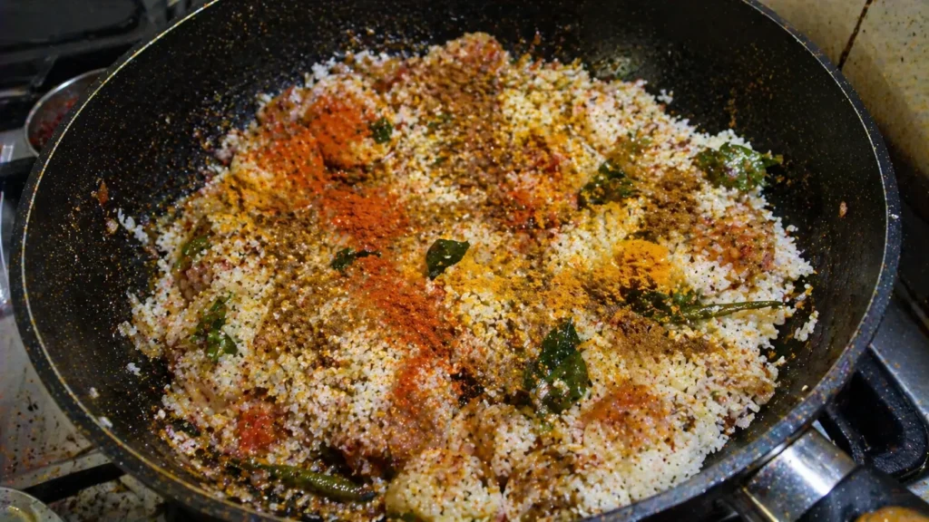 spices added to rice in pan with onions and tomatoes for one pot fish potato rice recipe
